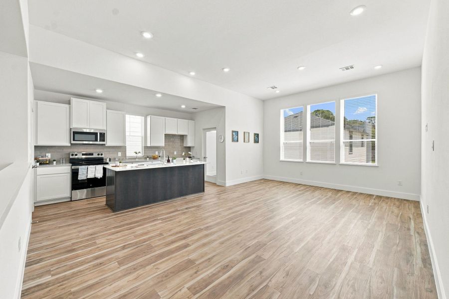 Modern kitchen featuring a large center island overlooking the spacious open-concept living area. Modern kitchen featuring a large center island overlooking the spacious open-concept living area.