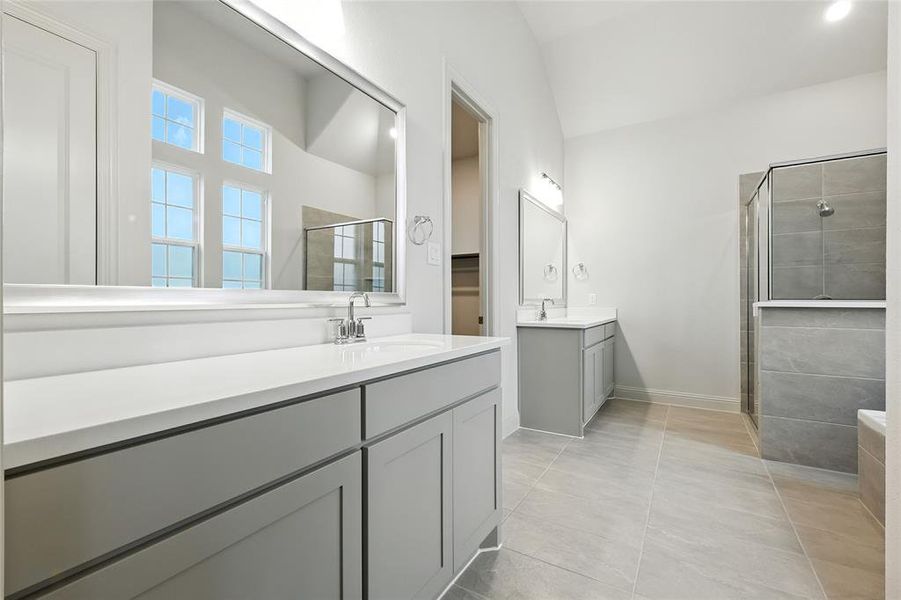 Bathroom with two vanities, a shower stall, and light tile patterned flooring