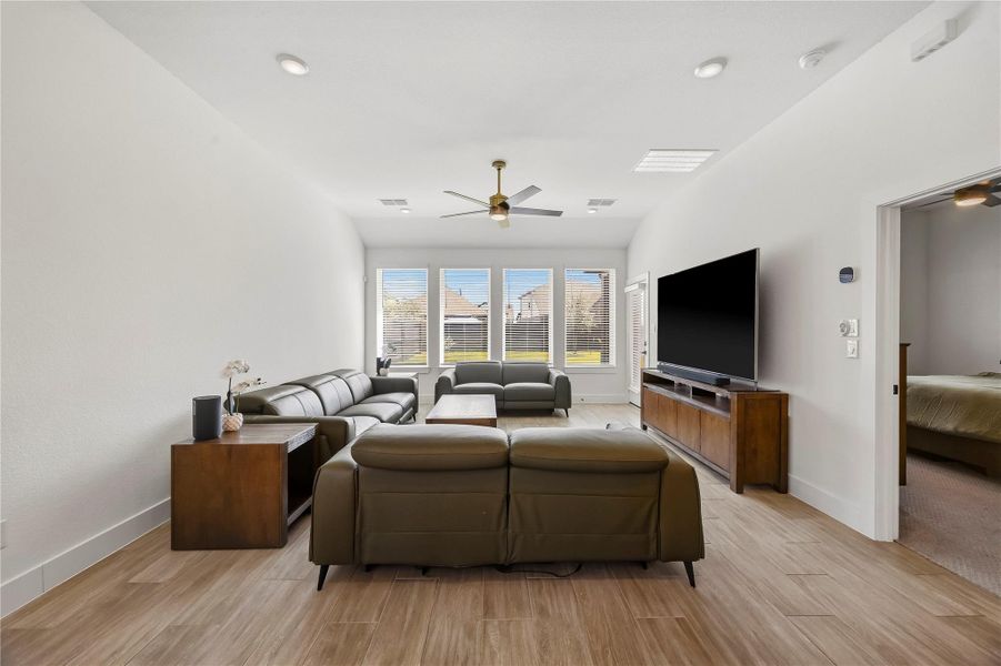 The living room pairs hardwood tile flooring with recessed lighting and a ceiling fan with integrated light, creating a warm, comfortable setting for relaxing or entertaining. The living room pairs hardwood tile flooring with recessed lighting and a ceiling fan with integrated light, creating a warm, comfortable setting for relaxing or entertaining.