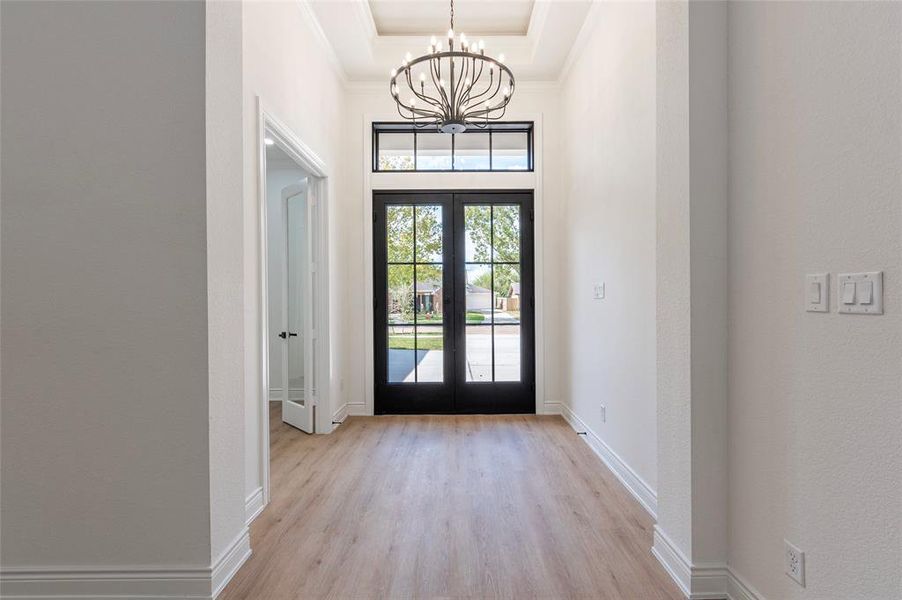 The formal entry has a coffered ceiling accented with a beautiful modern chandelier.