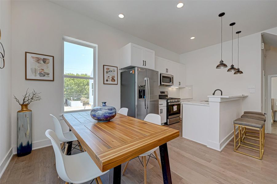 From breakfast to dinner parties, this light-filled dining area sits adjacent to a high-function kitchen featuring quartz countertops, white shaker cabinetry, and sleek stainless steel appliances a perfect flow for hosting.