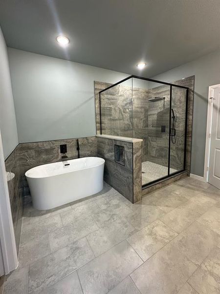 Bathroom with tile walls and separate shower and tub