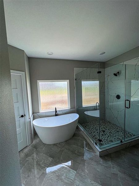 Bathroom with tile patterned flooring and shower with separate bathtub