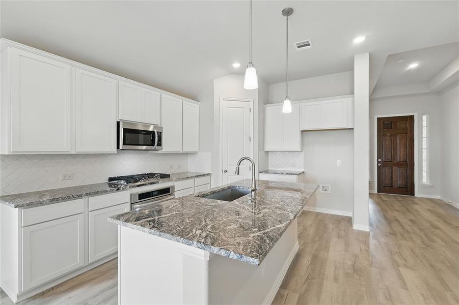 Kitchen featuring a sink, appliances with stainless steel finishes, light wood-style flooring, tasteful backsplash, and recessed lighting