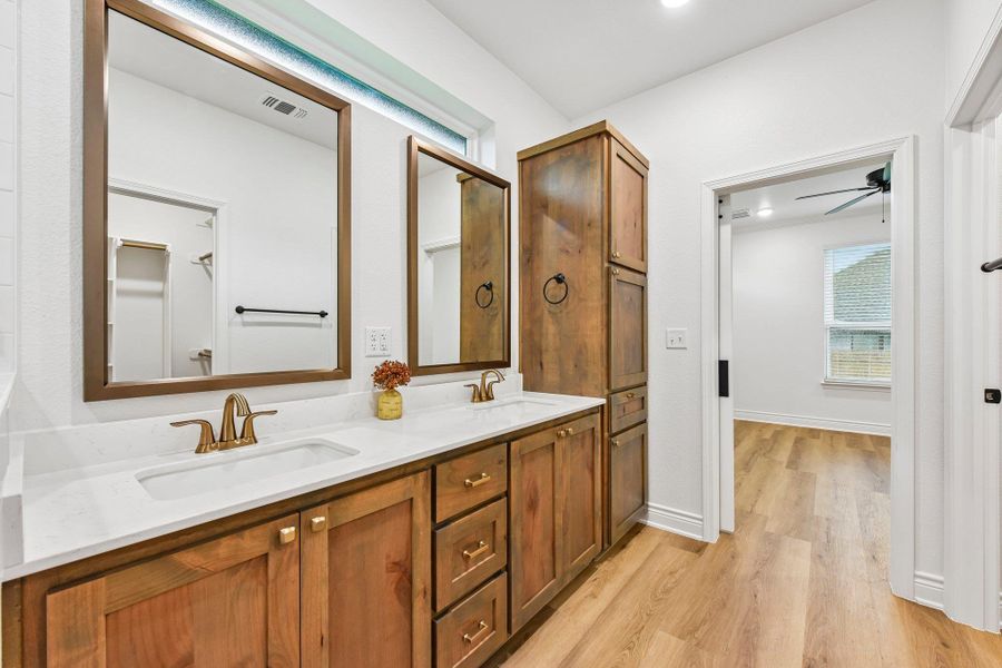 Dual vanities with sleek countertops and abundant storage elevate this modern bathroom's design. Dual vanities with sleek countertops and abundant storage elevate this modern bathroom's design.