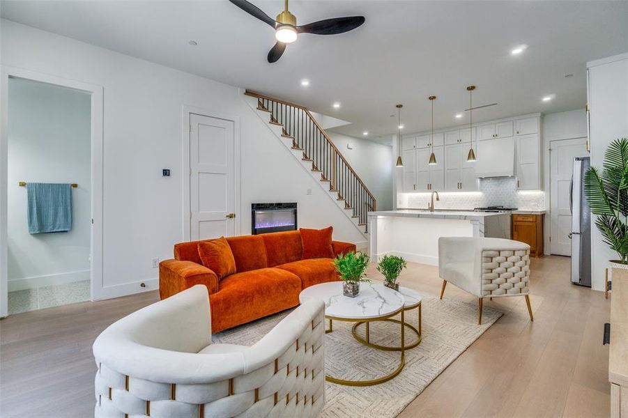 Living area featuring a ceiling fan, light wood finished floors, stairs, and recessed lighting