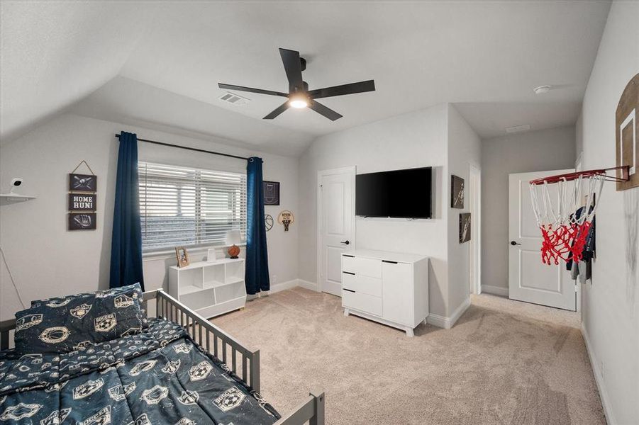 Bedroom featuring light colored carpet, a ceiling fan, and vaulted ceiling
