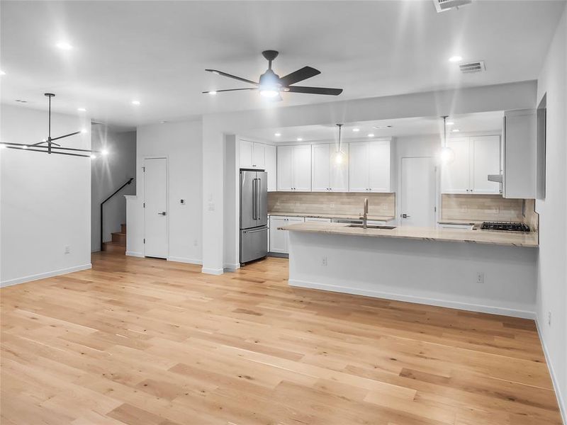 View of the kitchen from the sliding glass door. Down stair bedroom is left of the stairs.