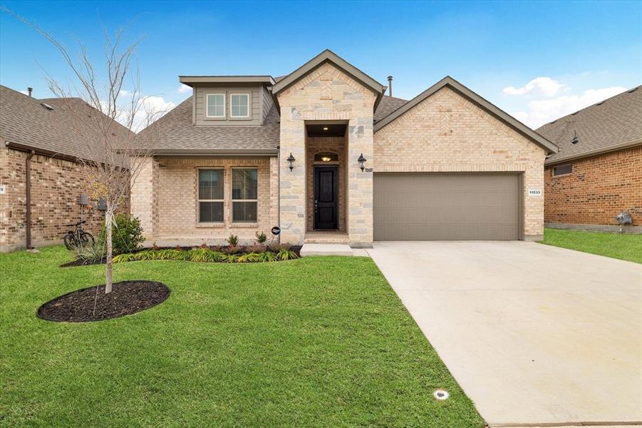 View of front of property with a garage and a front yard