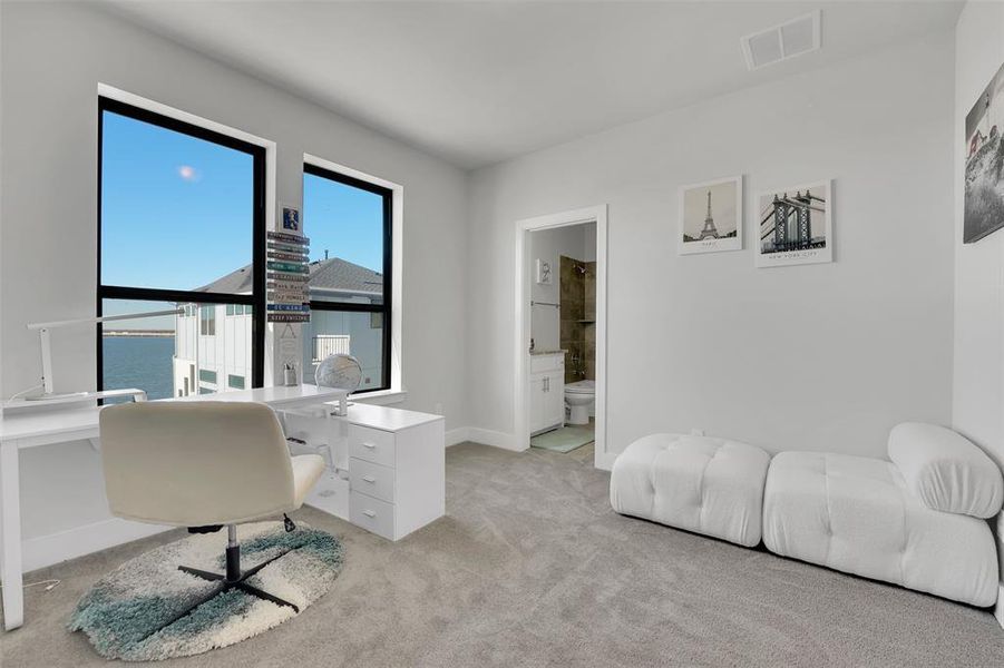 Office space featuring a water view and light colored carpet