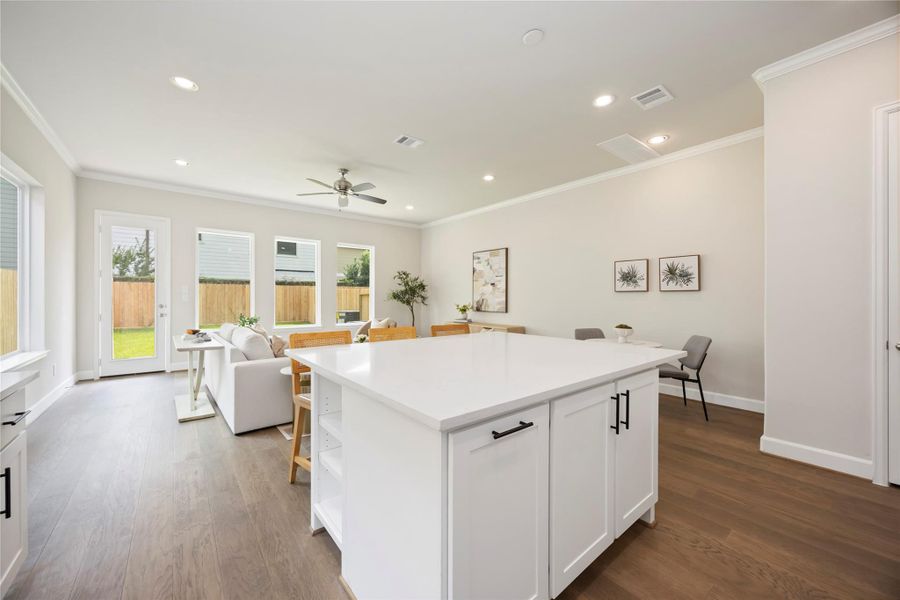 This huge island offers adjustable shelves, perfect for storing cookbooks or frequently accessed items, while providing a stunning view of the entire open-concept first-floor living space.