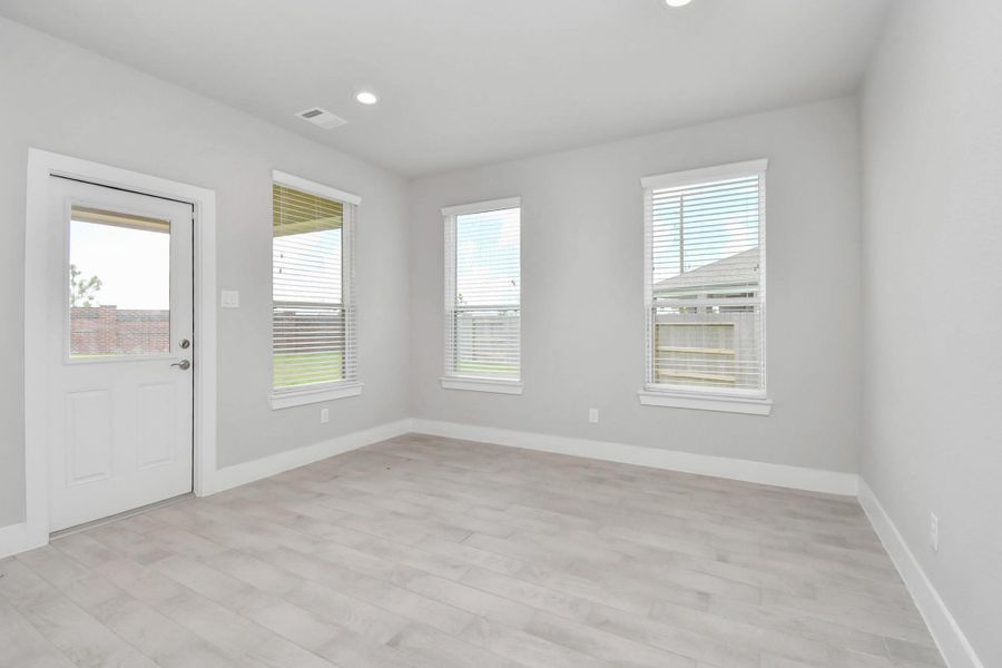 The back door, adorned with a window for natural light, opens gracefully to the covered patio. Sample photo of completed home with similar floor plan. Actual colors and selections may vary. The back door, adorned with a window for natural light, opens gracefully to the covered patio. Sample photo of completed home with similar floor plan. Actual colors and selections may vary.