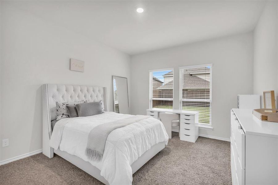 Bedroom featuring light carpet and baseboards Bedroom featuring light carpet and baseboards