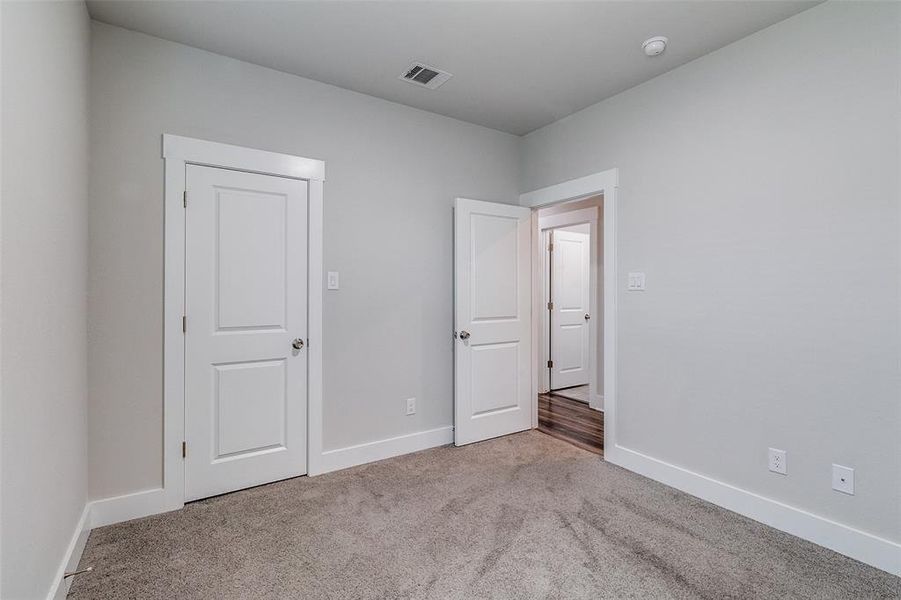 Unfurnished bedroom featuring carpet and baseboards