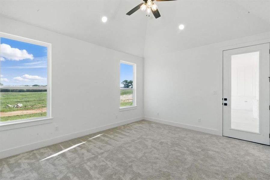 Carpeted empty room featuring vaulted ceiling, recessed lighting, and a ceiling fan Carpeted empty room featuring vaulted ceiling, recessed lighting, and a ceiling fan