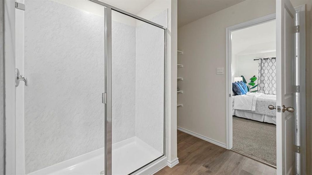 Bathroom with connected bathroom, a stall shower, and wood finished floors Bathroom with connected bathroom, a stall shower, and wood finished floors
