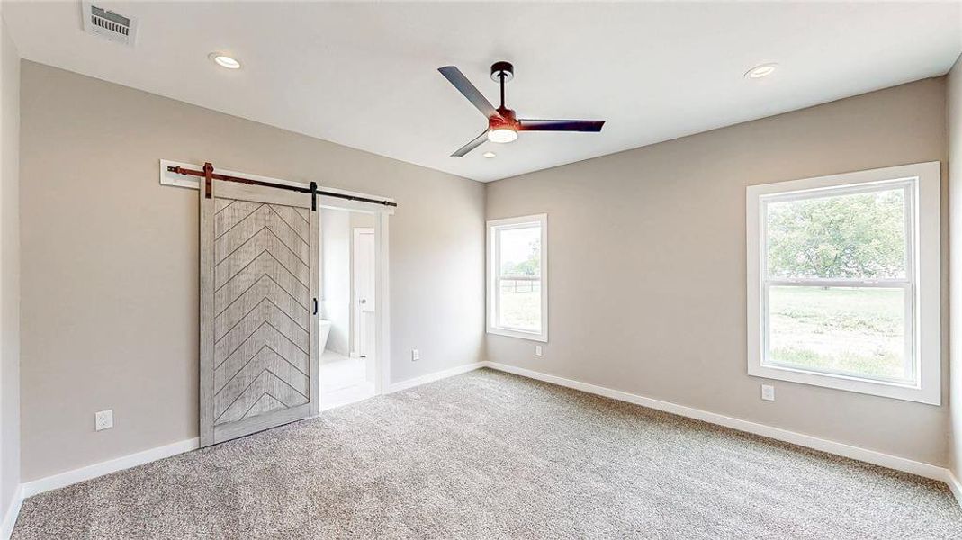 Spacious primary suite with sliding barn door & LED can lights