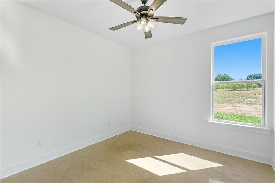 Spare room with finished concrete flooring and ceiling fan