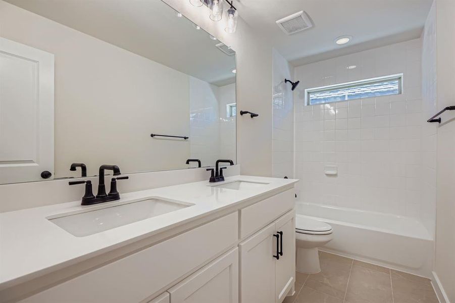 Bathroom with double vanity, light tile patterned floors, shower / washtub combination, and recessed lighting