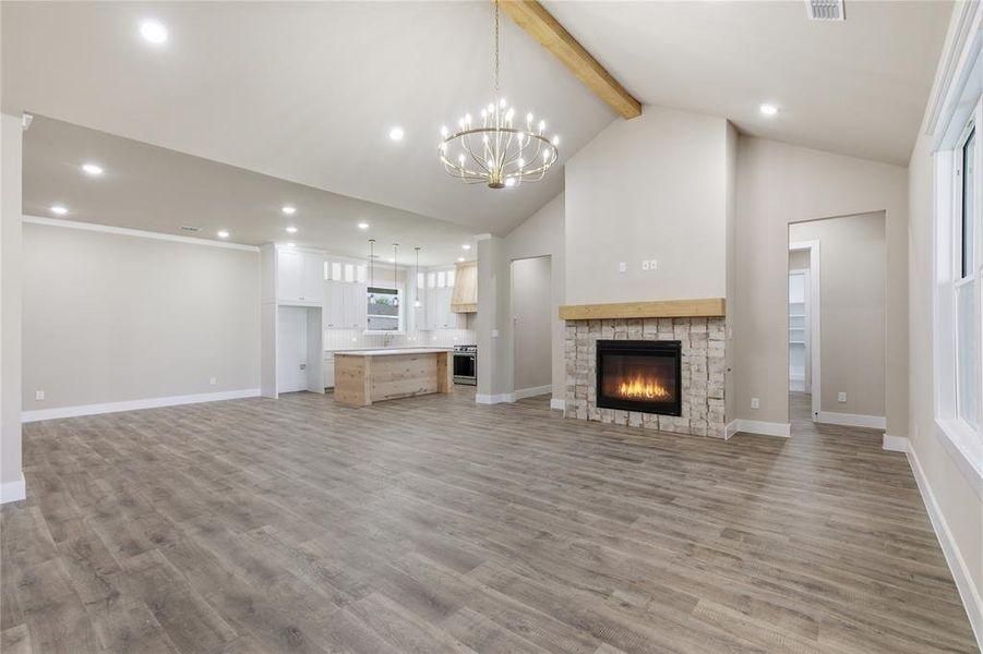 Open concept living space featuring wood-finish flooring, a vaulted ceiling, and recessed lighting