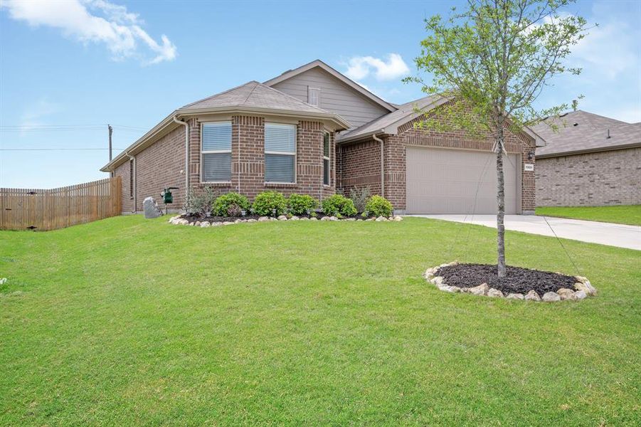 Ranch-style home featuring concrete driveway, brick siding, and a garage