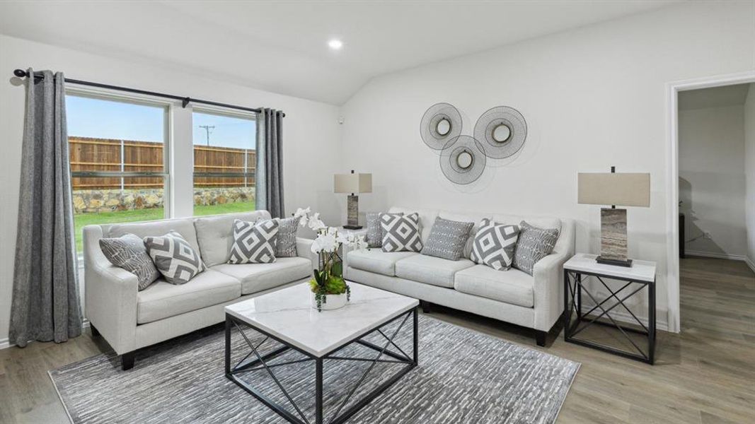 Living room featuring lofted ceiling, recessed lighting, and light wood-type flooring Living room featuring lofted ceiling, recessed lighting, and light wood-type flooring
