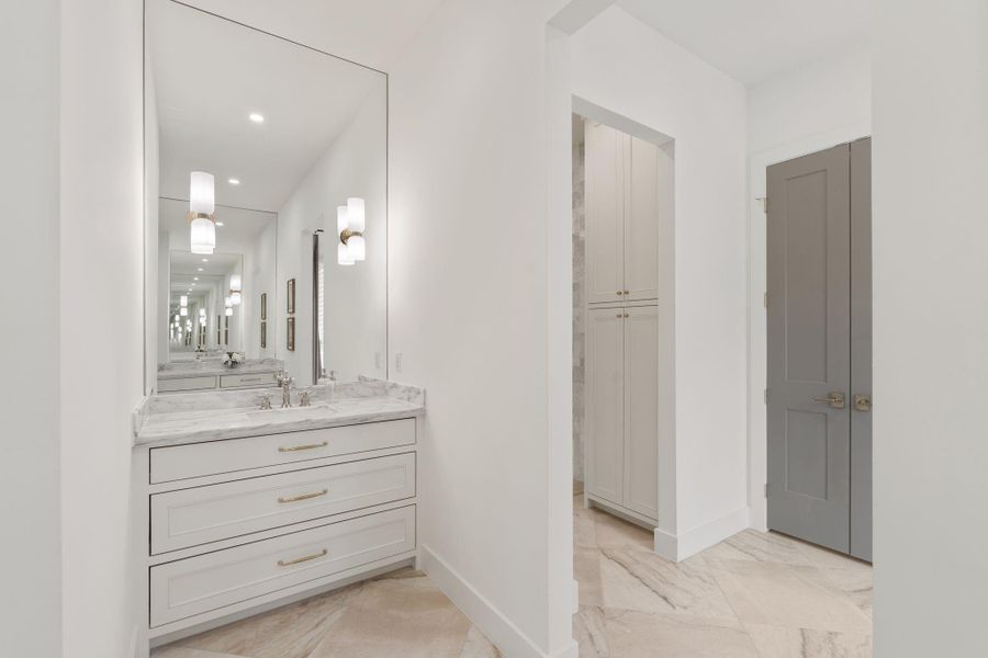 Large-format tile flooring creates a clean, upscale foundation, while the layout offers generous counter space and storage.