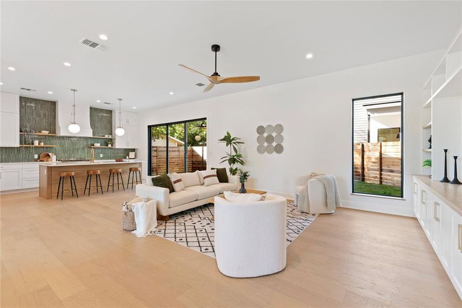 The kitchen flows into living room with large windows