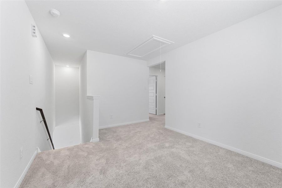 Another perspective of the Loft, showcasing the staircase and hallway leading to the secondary bedrooms.