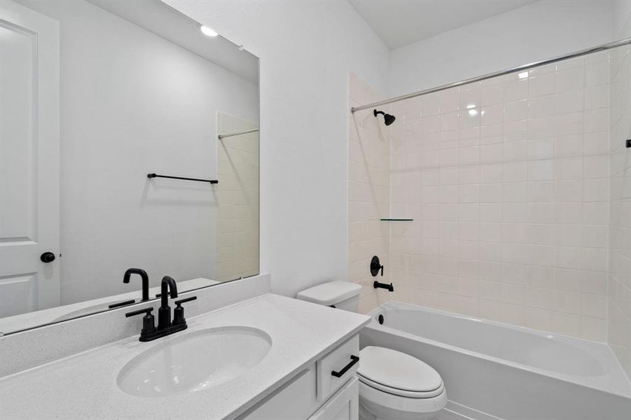 The secondary bath features tile flooring, white cabinetry and light countertops and a shower/tub combo. Perfect for accommodating any visiting family and friends.