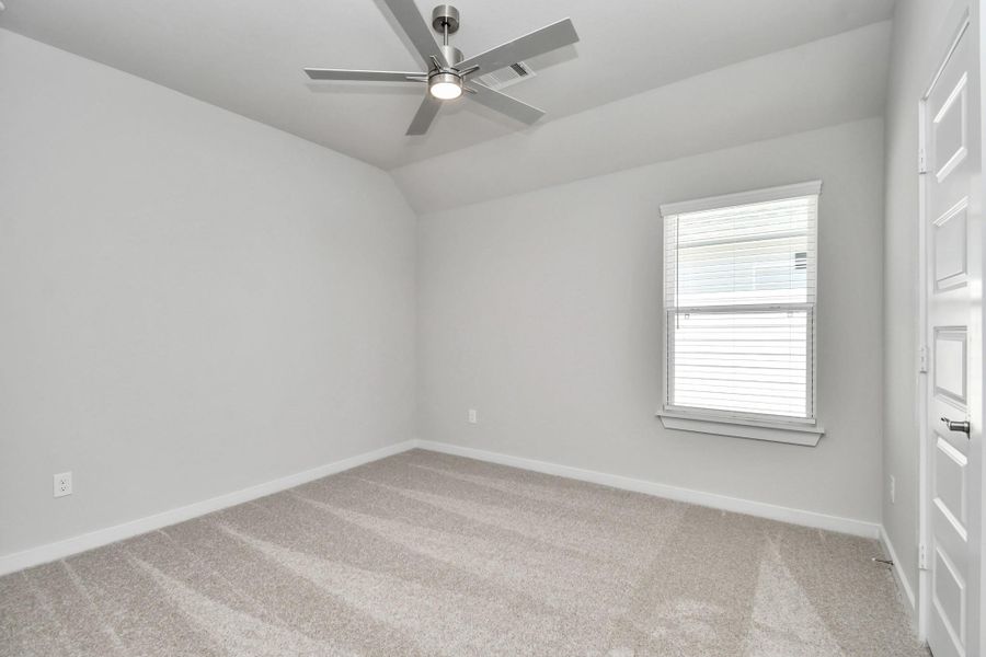 Secondary bedroom features plush carpeting, large windows that let in plenty of natural light, bright paint, and spacious closets. Sample photo of completed home with similar floor plan. Actual colors and selections may vary.