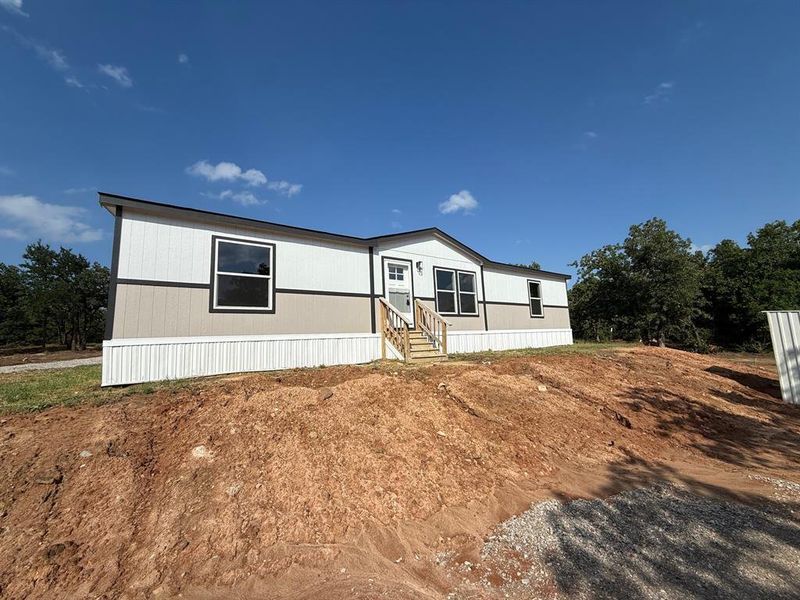 Contemporary manufactured home featuring a two-tone exterior with white vertical siding and beige horizontal siding Contemporary manufactured home featuring a two-tone exterior with white vertical siding and beige horizontal siding