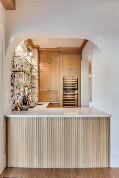 Kitchen featuring beverage cooler, arched walkways, and crown molding Kitchen featuring beverage cooler, arched walkways, and crown molding