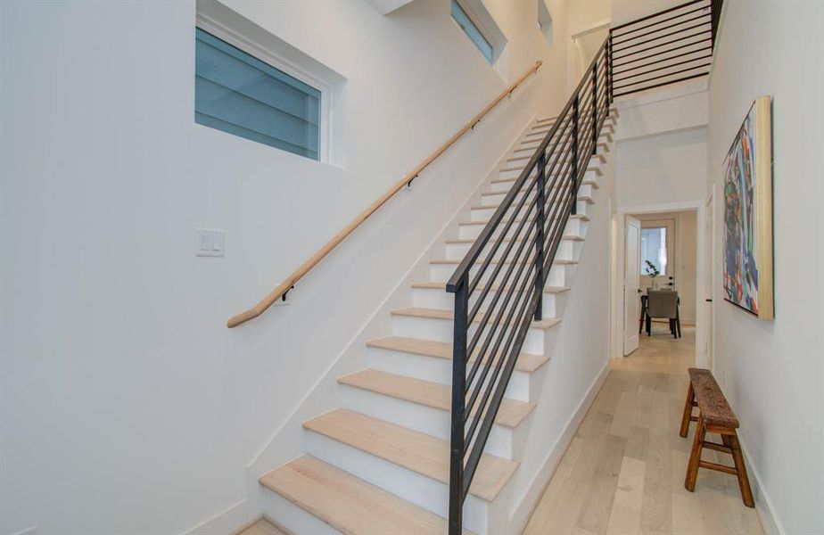 First level hallway with a storage closet under the staircase and double ceilings