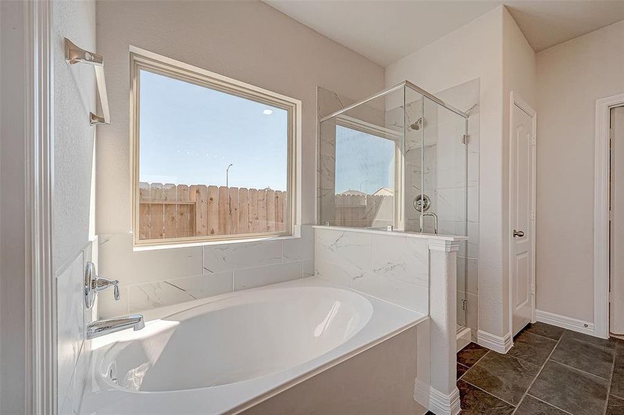 A soaking tub & separate shower are accented with beautiful tile.