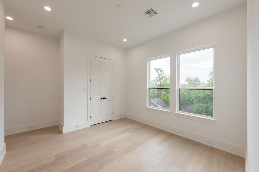The second bedroom located on the third floor boasts natural lighting and soaring cielings.