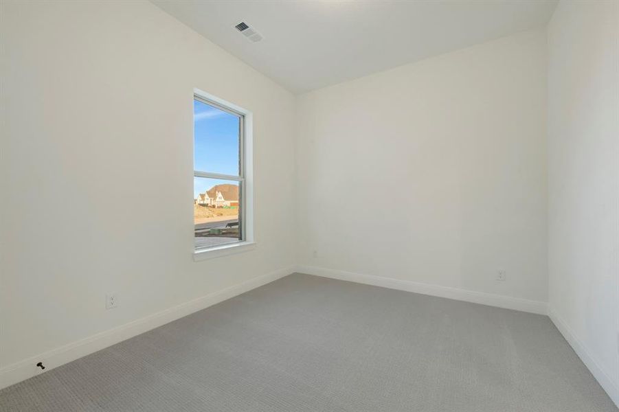 Carpeted spare room featuring baseboards Carpeted spare room featuring baseboards