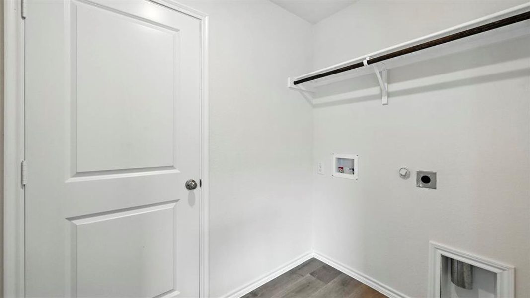 Dedicated laundry area featuring a white bi-fold door, a clothing rod with shelving, and utility hookups for appliances Dedicated laundry area featuring a white bi-fold door, a clothing rod with shelving, and utility hookups for appliances