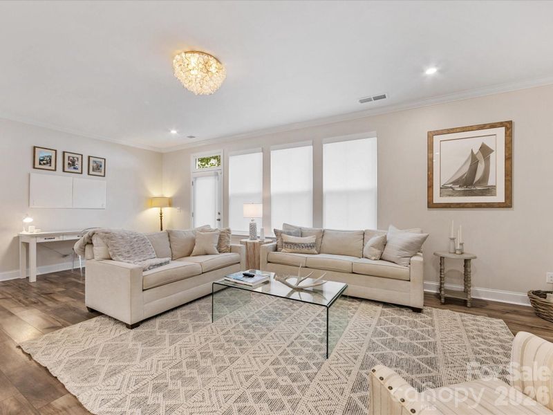 Natural light floods the home through many tall windows with custom Hunter Douglas shades.