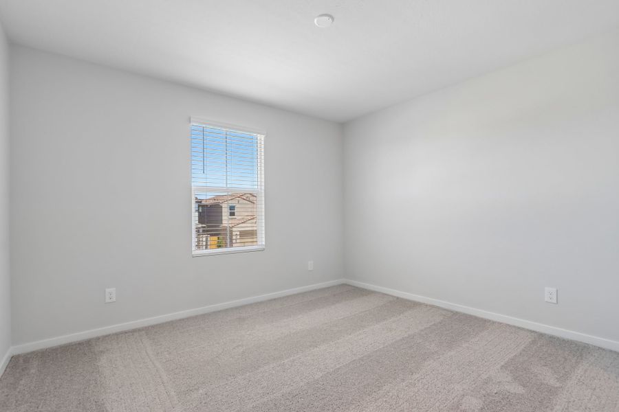 A room with a window and a rug.