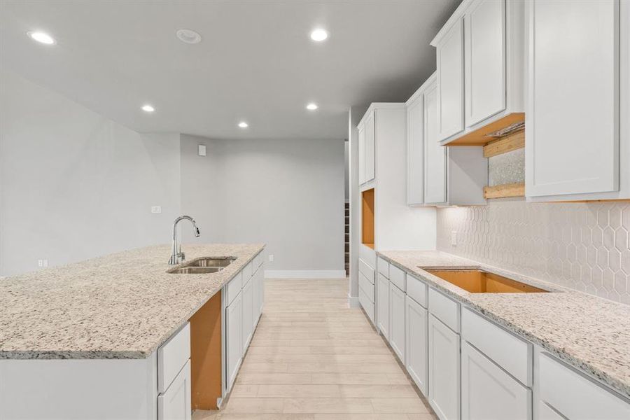 Discover another perspective of this stunning kitchen, generously appointed with an abundance of counter space. Sample photo of completed home with similar floor plan. Actual colors and selections may vary.