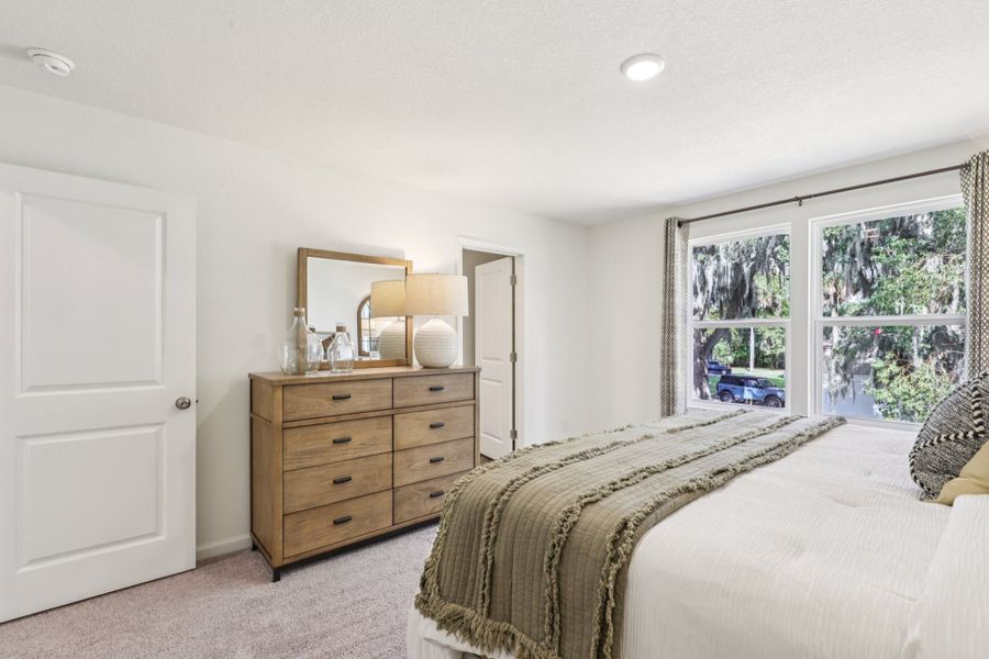 A bedroom with a bed and dresser. A bedroom with a bed and dresser.