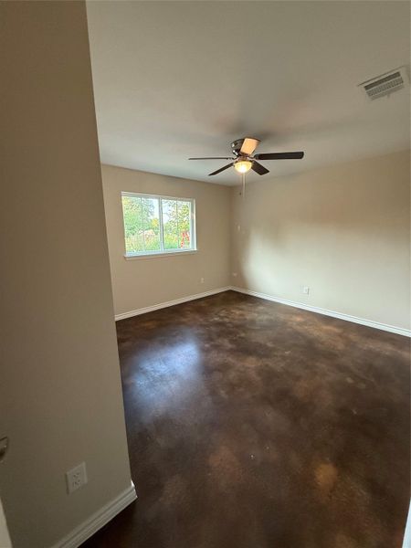 Spare room featuring finished concrete floors and ceiling fan Spare room featuring finished concrete floors and ceiling fan
