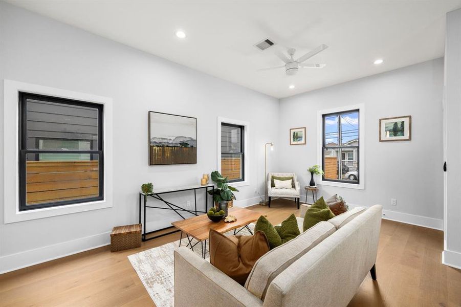 Another view of the living room showcasing the large windows and all the natural lighting.