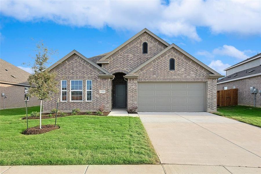 View of front of home with a front yard and a garage