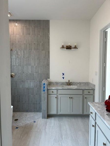 Luxurious tile in the primary shower and separate vanity tops.