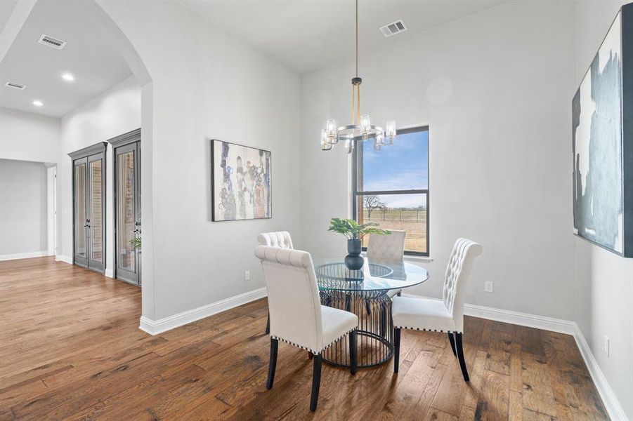 Dining area with a chandelier and hardwood / wood-style flooring