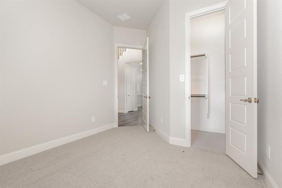 Unfurnished bedroom featuring baseboards and light carpet