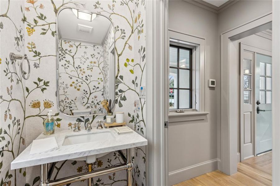 Bathroom with a sink, baseboards, and wood finished floors