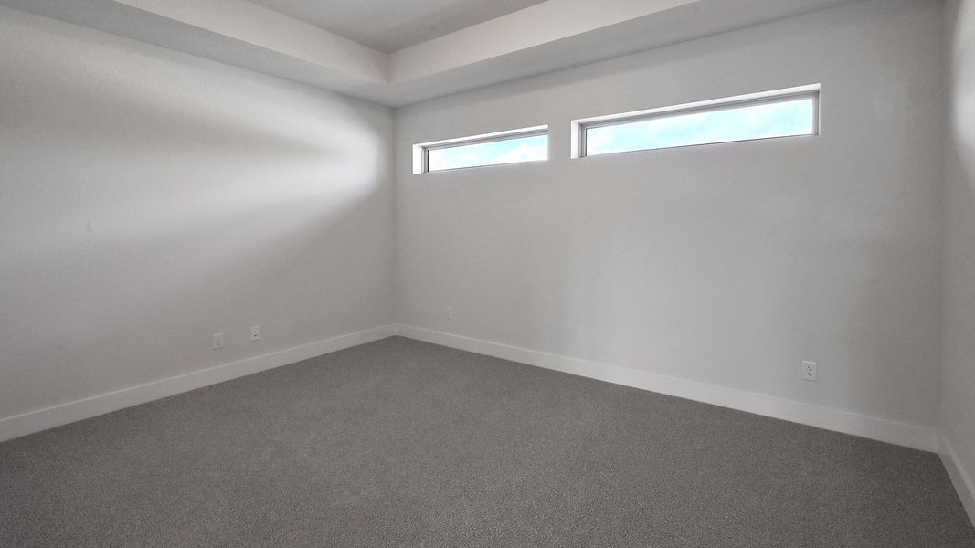 Empty room featuring plenty of natural light and dark carpet Empty room featuring plenty of natural light and dark carpet